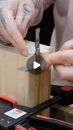 a man is using a drill to cut wood with a small piece of pliers