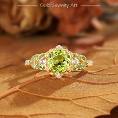 a yellow and white diamond ring on top of a leafy brown surface with the words gold jewelry art written below it