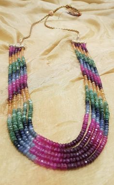 This is a five strand multicoloured sapphire necklace with a highly adjustable length. Bead size is 2-4mm. The necklace was handmade in Hyderabad, India which is renowned for crafting exquisite and intricate designs and has a rich history in the art of jewellery making which dates back centuries. The artisans in Hyderabad are skilled in creating unique designs that often incorporate cultural and historical elements, making the jewellery not just a fashion statement but also a piece of art. The c Luxury Double Strand Gemstone Beaded Necklaces, Luxury Beaded Necklaces With Multi-stone For Gift, Luxury Multicolor Long Beaded Necklaces, Luxury Multicolor Faceted Beads Necklace, Multicolor Round Beads Jewelry For Celebration, Multicolor Gemstone Beads Jewelry For Celebration, Multicolor Gemstone Beads Necklace For Gift, Rainbow Multi-strand Necklace As Gift, Multicolor Polished Beads Jewelry For Celebration