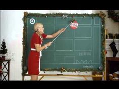 a woman in a red dress is writing on a blackboard with a pinwheel