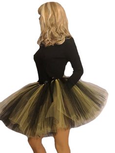 a woman in a black top and green tutu skirt is looking back at the camera