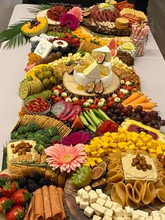 a table topped with lots of different types of foods and cheeses on top of it