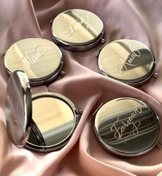 three compact mirrors sitting on top of a pink cloth