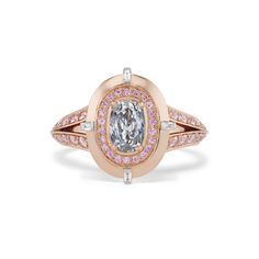 an oval shaped ring with pink and white diamonds on the sides, set in 18k rose gold