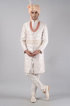 Tint pink sherwani embroidered with kasab all-over, embellished with pastel resham French knots and challa work. Paired with tint pink kurta and churidar.
Component: 3
Pattern: Embroidered
Type Of Work: Kasab pita work, French knots, crystals
Neckline: Mandarin
Sleeve Type: Full Sleeves
Fabric: Raw Silk
Color: Pink
Other Details: 
Floral motifs
Front buttons
Note: Neckpiece, kamarbandh and head accessory worn by the model is not for sale
Occasion: Groom, Wedding - Aza Fashions Traditional Bandhgala For Reception During Diwali, Reception Sets With Naqshi In Traditional Drape, Semi-stitched Naqshi Traditional Wear For Reception, Embroidered Sherwani For Reception During Transitional Season, Embroidered Sherwani For Reception And Transitional Season, Embroidered Sherwani For Reception, Naqshi Embellished Sherwani For Eid Reception, Eid Sherwani With Naqshi For Reception, Eid Reception Sherwani With Naqshi