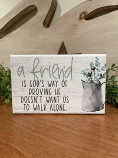 a wooden sign that says, a friend is god's way of providing us doesn't want us to walk alone