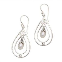 Concentric teardrop-shaped sterling silver wire cages grasp cultured freshwater pearls in these dangle earrings by Balinese artisan Diah Arini. The pearls are held in place by leafy caps which gives them the look of tender buds about to bloom. Pierced Teardrop Pearl Earrings In Sterling Silver, Sterling Silver Teardrop Dangle Earrings With Pearl Drop, Pierced Teardrop Pearl Earrings, Silver Teardrop Chandelier Earrings With Pearl Drop, Delicate Silver Teardrop Pearl Earrings, Sterling Silver Teardrop Pearl Earrings, Silver Teardrop Wire Wrapped Pearl Earrings, Delicate Silver Teardrop Earrings, Pearl Dangle Earrings