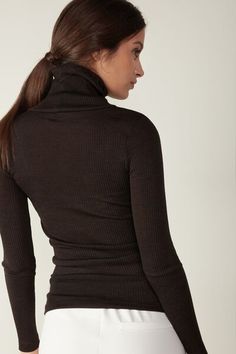 Long-sleeve high-neck tubular top made from a wool-silk blend. Brown Fine Knit Turtleneck Top, Merino Wool Turtleneck Top For Work, Merino Wool Turtleneck Top, Fitted Fine Knit Merino Wool Tops, Fitted Merino Wool Fine Knit Tops, Stretch Merino Wool Tops In Solid Colors, Stretch Merino Wool Solid Top, Stretch Merino Wool Solid Color Tops, Fitted Brown Long Sleeve Turtleneck