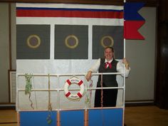 a woman standing in front of a life preserver with her hands up and smiling