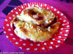 two pastries sitting on top of a red paper plate with white polka dot dots