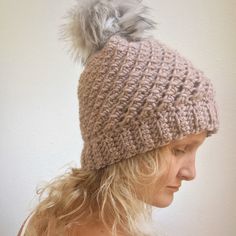 a woman wearing a knitted hat with a pom - pom