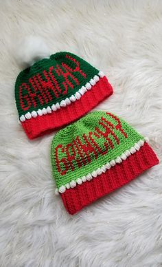 two knitted hats with the word santa written in red, green and white on them