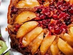 an apple and cranberry upside down cake on a white plate with silverware