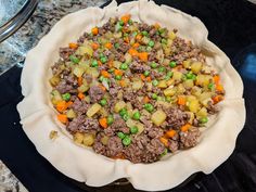 there is a pie with meat and vegetables in it on the stove top, ready to be cooked