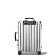 a silver suitcase sitting on top of a white floor next to a black and gray handle