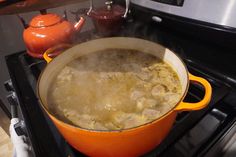 an orange pot filled with food on top of a stove