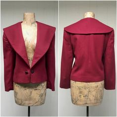 * Cropped wool jacket c 1980s* Cranberry wool fabric* Super wide shawl collar * Long, set-in sleeves* Padded shoulders* Antiqued engraved metal buttons on chain closure* Cranberry satin liningExcellent condition. There is a stain on the lining that does not show through. See last image.Label: Evan Picone, ILGWU, Woolmark 100% imported wool - Made in USA - 12Bust: 40Waist: 38Sleeve: 21Length: 20Garments are flat-measured. Please compare these measurements to another flat-measured garment that fit Vintage Fitted Outerwear With Shawl Collar, Fitted Vintage Outerwear With Shawl Collar, Crop Jacket Pattern, 80s Suit, Engraved Metal, How To Iron Clothes, Cropped Blazer, Jacket Pattern, Wool Fabric