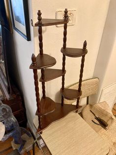 three wooden shelves stacked on top of each other next to a chair and table in a room