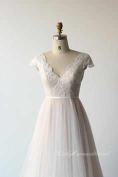 a white dress on a mannequin dummy with a lace top and tulle skirt