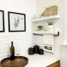 a bathroom with two framed pictures on the wall and a wine glass in the sink