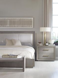 a bedroom with a bed, night stand and two nightstands in front of a window