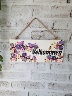 a sign hanging on the side of a brick wall that says, velkommen