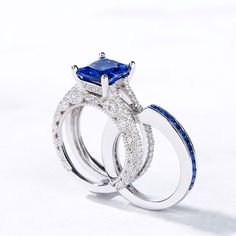 This eye-catching interchangeable ring set features an enchanting radiant cut stone and rows of smaller stones embellish the engagement ring in profile. Milgrain detailing along the ring's shank adds depth and dimension to this elegant design. Additional stones are set into the matching band. Gleaming with your love, this slender wedding set is a true reminder of your everlasting love.Carat Weight: 5.2 ctStone Size: 8*10 mmStone Type: Jeulia® StoneNumber of Stones: 1 Stone Color: Sapphire BlueStone Shape: RadiantCarat Weight: 3.24 ctStone Size: 1.5*1.5,2,1.75,1.5,1.25,1.2 mmStone Type: Jeulia® StoneNumber of Stones: 130 Stone Color: Sapphire Blue, Diamond WhiteStone Shape: Princess, RoundWeight: 7.26 gWidth: 10.55 mmHeight: 8.65 mmThickness: 7.6 mmMaterial: 925 SilverPlating Color: Silver Sapphire Blue Wedding, Sapphire Blue Weddings, Jeulia Jewelry, Blue Wedding Rings, Sterling Silver Rings Set, Silver Ring Set, Wedding Ring Set, Radiant Cut, Wedding Set