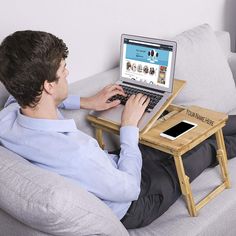 a man sitting on a couch using a laptop computer