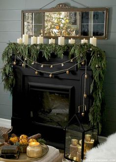 a living room with a fireplace decorated for christmas and candles on the mantels