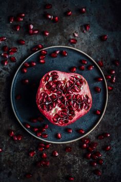 a pomegranate on a plate surrounded by red and black color swatches