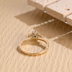 a diamond ring sitting on top of a piece of paper next to a white bench