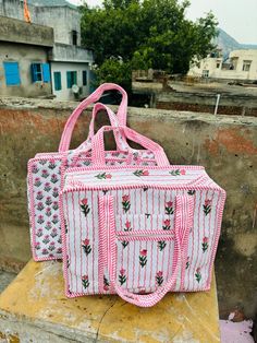 a pink and white bag sitting on top of a cement block