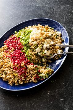 a blue plate topped with rice and veggies on top of a black table