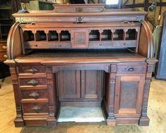 an old wooden desk with lots of drawers and cupboards on it's sides