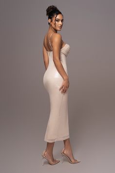 a woman in a white dress posing for the camera with her hands on her hips