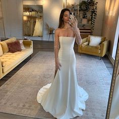 a woman taking a selfie in her wedding dress while standing in front of a mirror