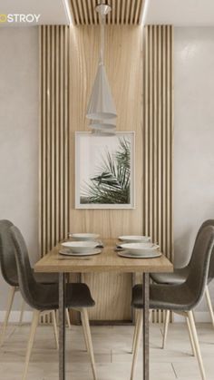 a dining room table with four chairs and a plant in the corner next to it