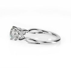 a white gold ring with an oval cut diamond in the center, on a white background