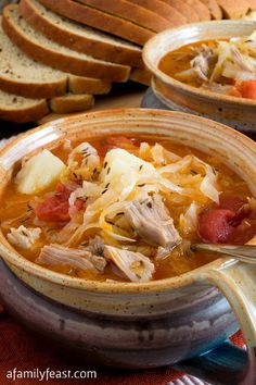 two bowls filled with soup next to slices of bread