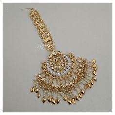 *PRODUCT DETAIL* *Material: Brass *Plating: Gold Plated *Stone: Semi Precious Kundan & Pearls *DIMENSIONS * *Tikka: Weight: 71 gm, Length: 4 Inches, Width: 2.6 Inches, Top Chain Length: 3.12 Inches *Earrings: Weight: 59 gm each, Length: 4.14 Inches, Width: 2.08 Inches *ABOUT PRODUCT* *Beautiful Jadau Kundan Maang Tikka in gold plating and pearl detailing. *Style Tip : A piece to Bring out your Eye for Exclusivity. *DISCLAIMER* *Product & color may slightly vary due to photographic lighti Wedding Temple Jewelry Danglers With Cutdana, Kundan Tilla Bridal Earrings For Wedding, Kundan Bridal Accessories With Tilla For Marriage, Kundan Bridal Earrings For Marriage, Wedding Temple Jewelry Danglers With Tilla, Traditional Wedding Danglers With Cutdana, Traditional Danglers With Cutdana For Wedding, Kundan Tikka With Latkans For Celebration, White Kundan Bridal Earrings For Marriage