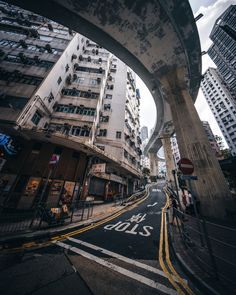 an empty city street with tall buildings in the background and graffiti written on the road