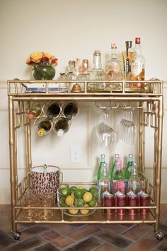 the bar cart is filled with bottles and glasses