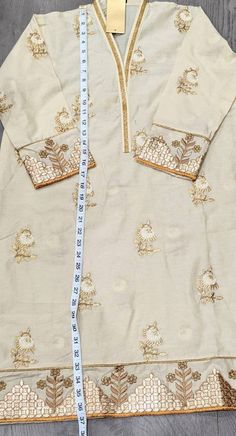 Embroidered Anarkali Kurta For Eid, Unstitched Beige Kurta For Festive Occasions, Unstitched Straight Kurta With Intricate Embroidery, Festive Embroidered Straight Kurta Lawn Suit, Festive Embroidered Lawn Suit With Straight Kurta, Festive Lawn Suit With Embroidered Straight Kurta, Eid Anarkali Embroidered Fabric With Long Sleeve, Eid Anarkali Long Sleeve Embroidered Fabric, Unstitched Long Sleeve Suit With Floral Embroidery For Navratri