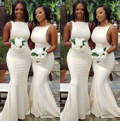 three women in white dresses standing next to each other and one is holding a bouquet