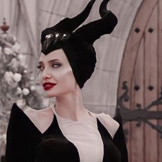 a woman in black and white dress with horns on her head