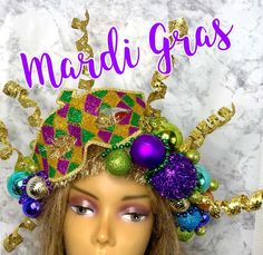 a mannequin head wearing a mardi gras hat with ornaments on it