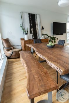 a wooden table with two benches in front of it and a flat screen tv on the wall