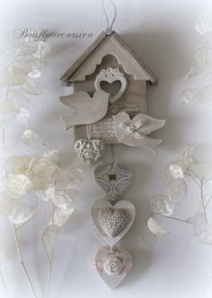 a bird house with hearts hanging from it's side