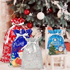 three christmas bags sitting next to a christmas tree