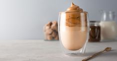 a glass filled with liquid sitting on top of a table next to some cookies and milk